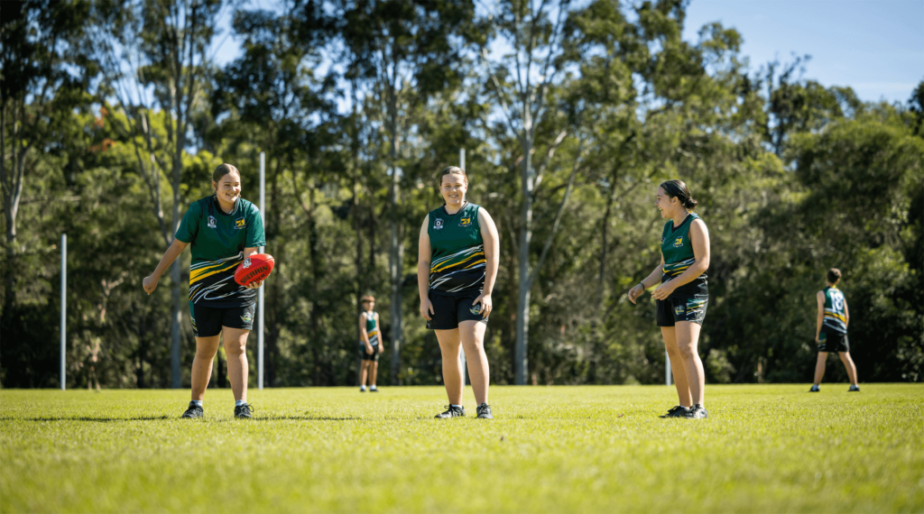 Young kids in a field playing AFL